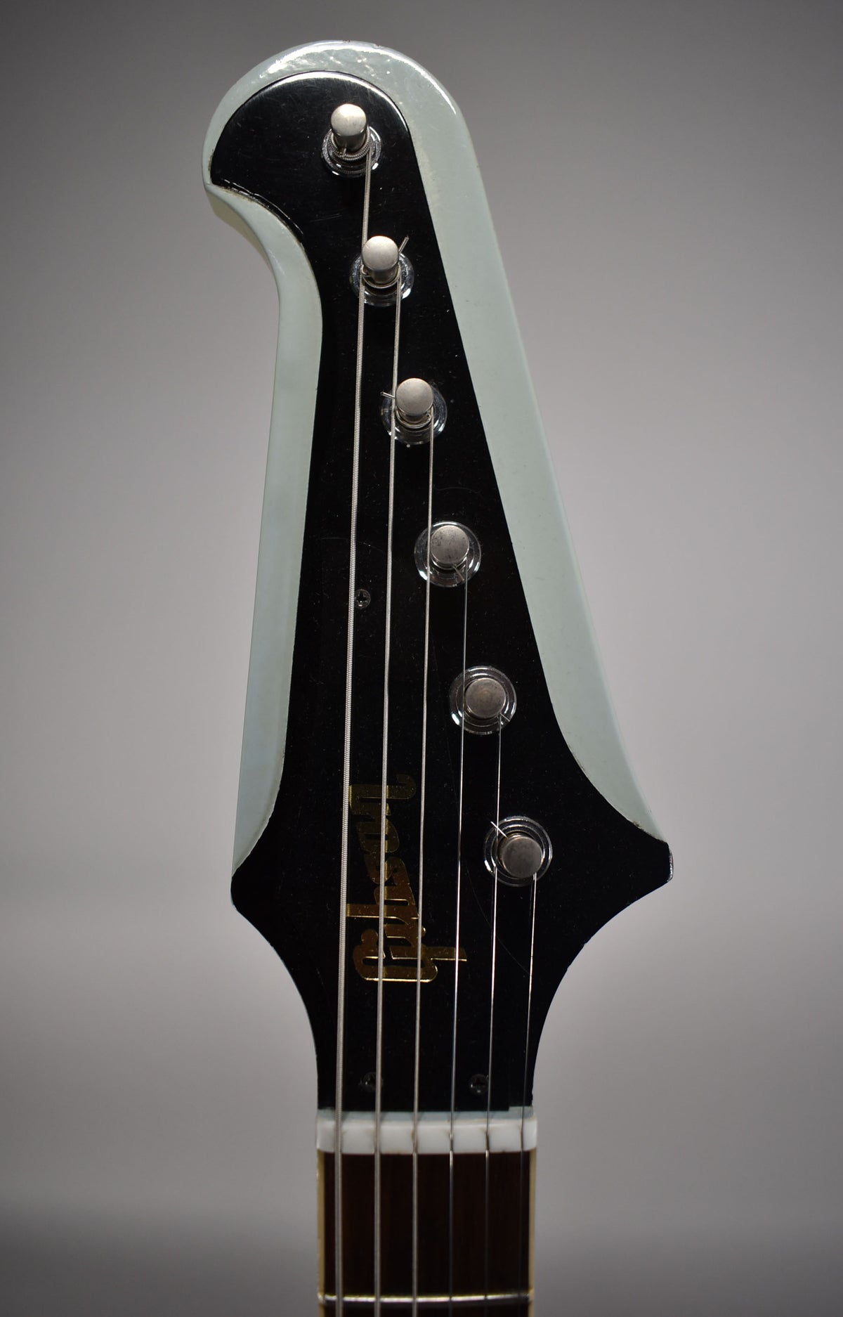 The guitar's headstock, finished in Frost Blue with a black face, features six chrome tuners and a gold logo, showing light wear.