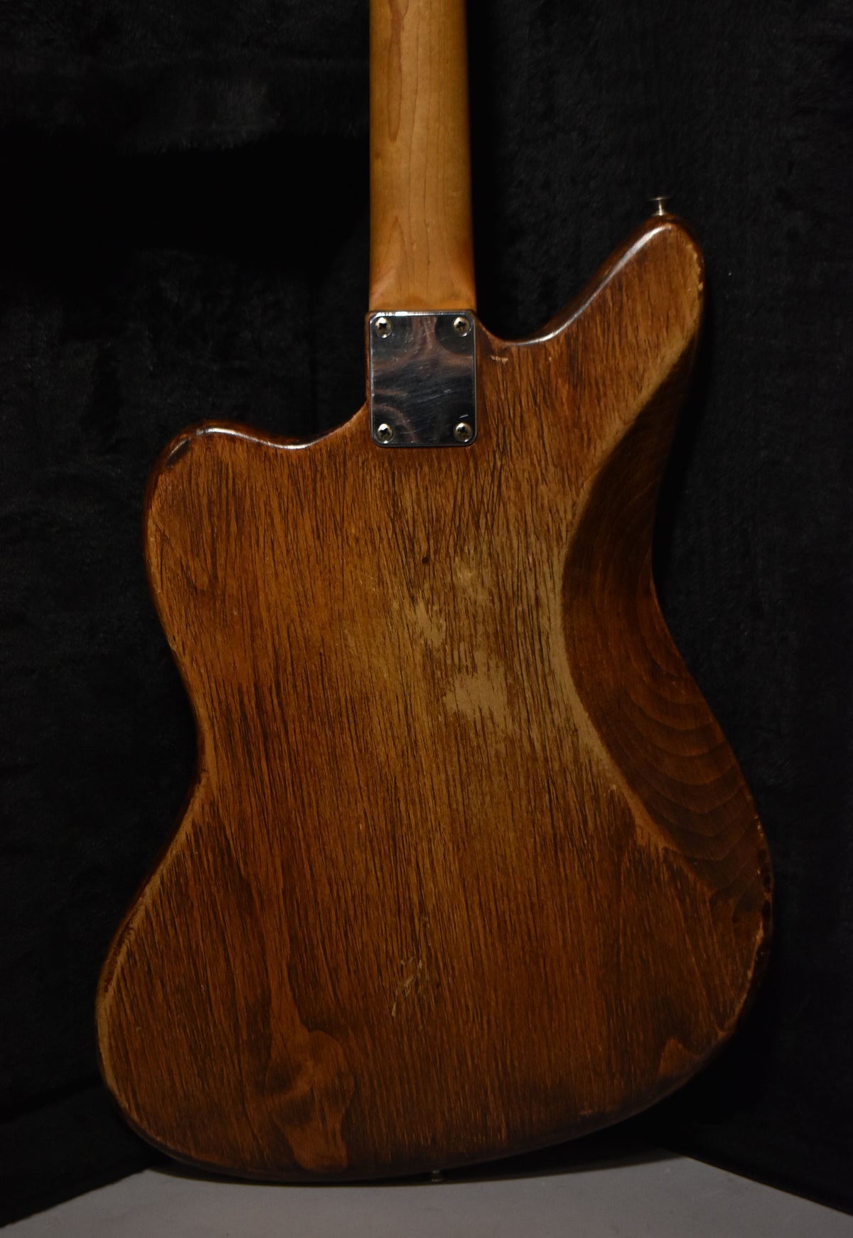 The back of the guitar shows a natural wood grain body with a worn, matte finish, a chrome neck plate, and a light-colored neck.