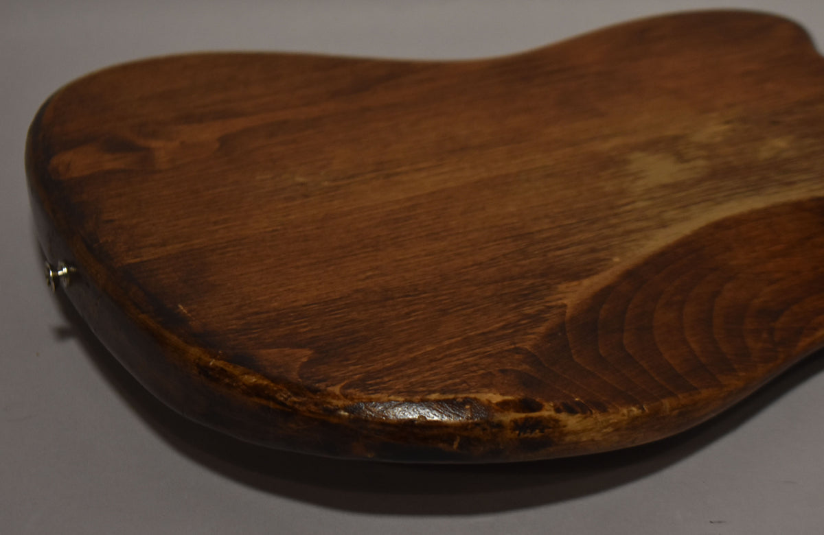 Close-up of the guitar's lower body, showing the natural wood grain and worn, chipped finish along the curved edge and input jack.