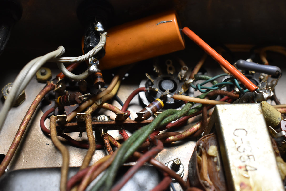 A close-up of the amp's internal wiring shows a tangle of colorful wires, resistors, and capacitors, with a large orange capacitor prominent.