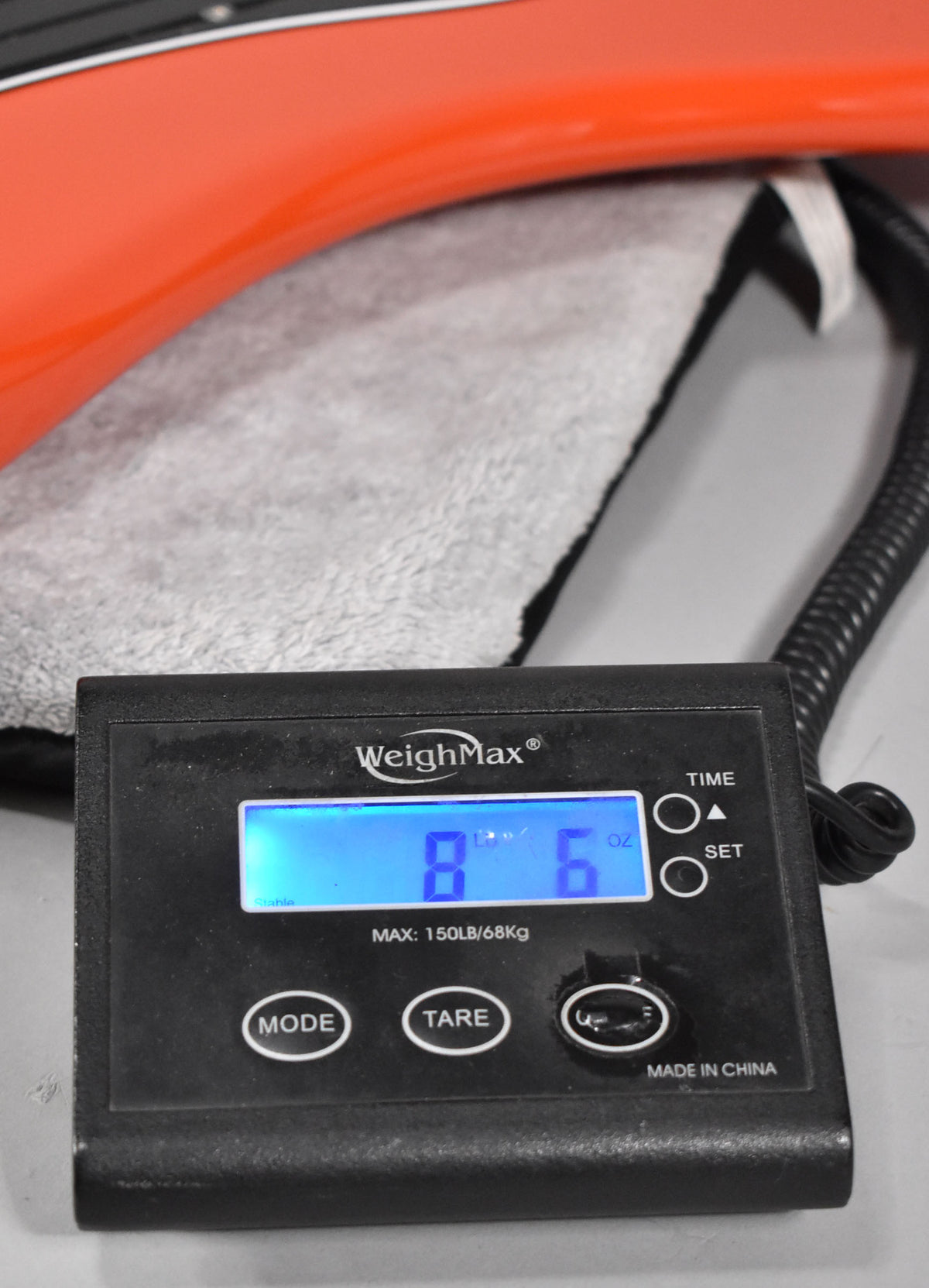 The coral red bass body rests on a towel, with a digital scale in the foreground displaying "8 Lb 6 Oz".