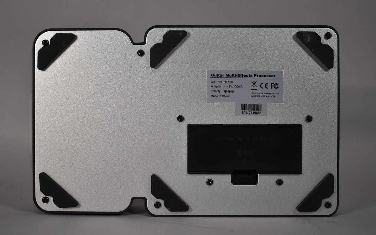 The pedal's silver-gray textured underside is visible, featuring four black rubber feet and a battery compartment with "OPEN" text.