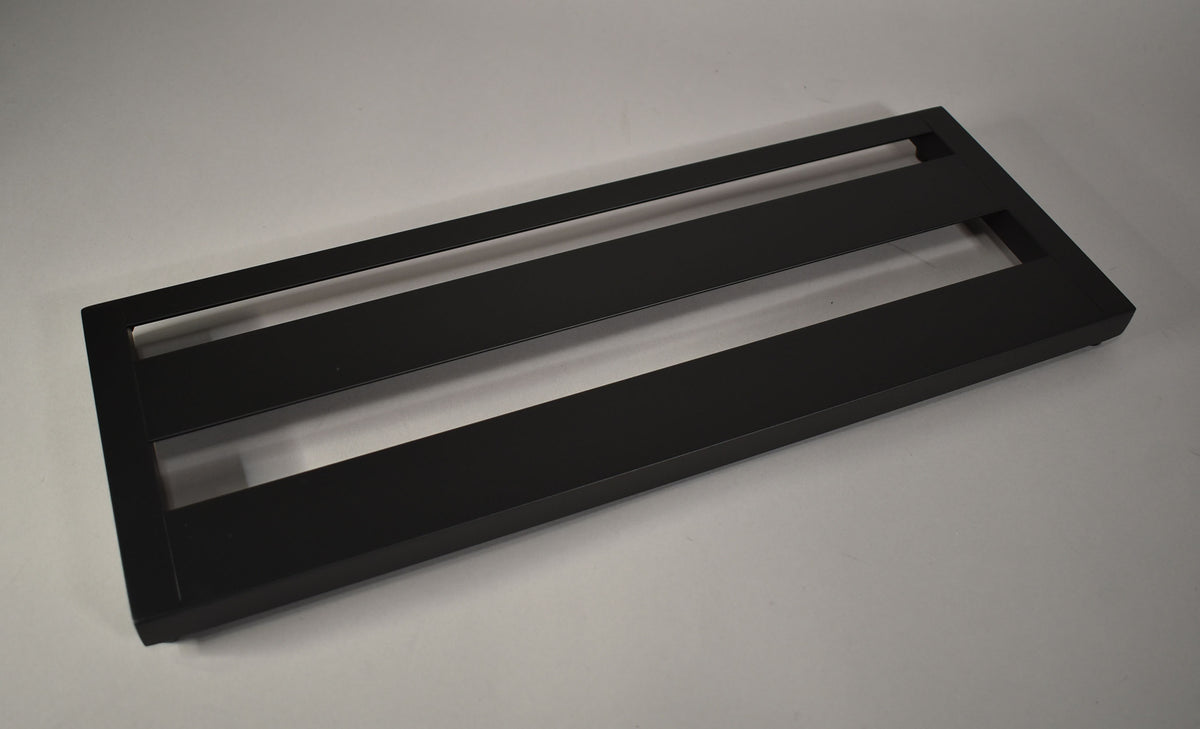 The black pedalboard is shown from a high angle, revealing three horizontal slats and a slight upward tilt.