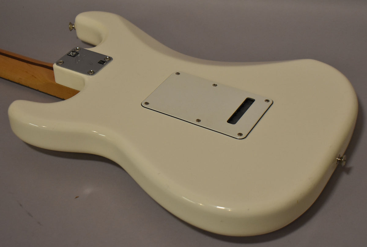 The back of a polar white Stratocaster body, showing the neck plate, tremolo cover, and a strap button.