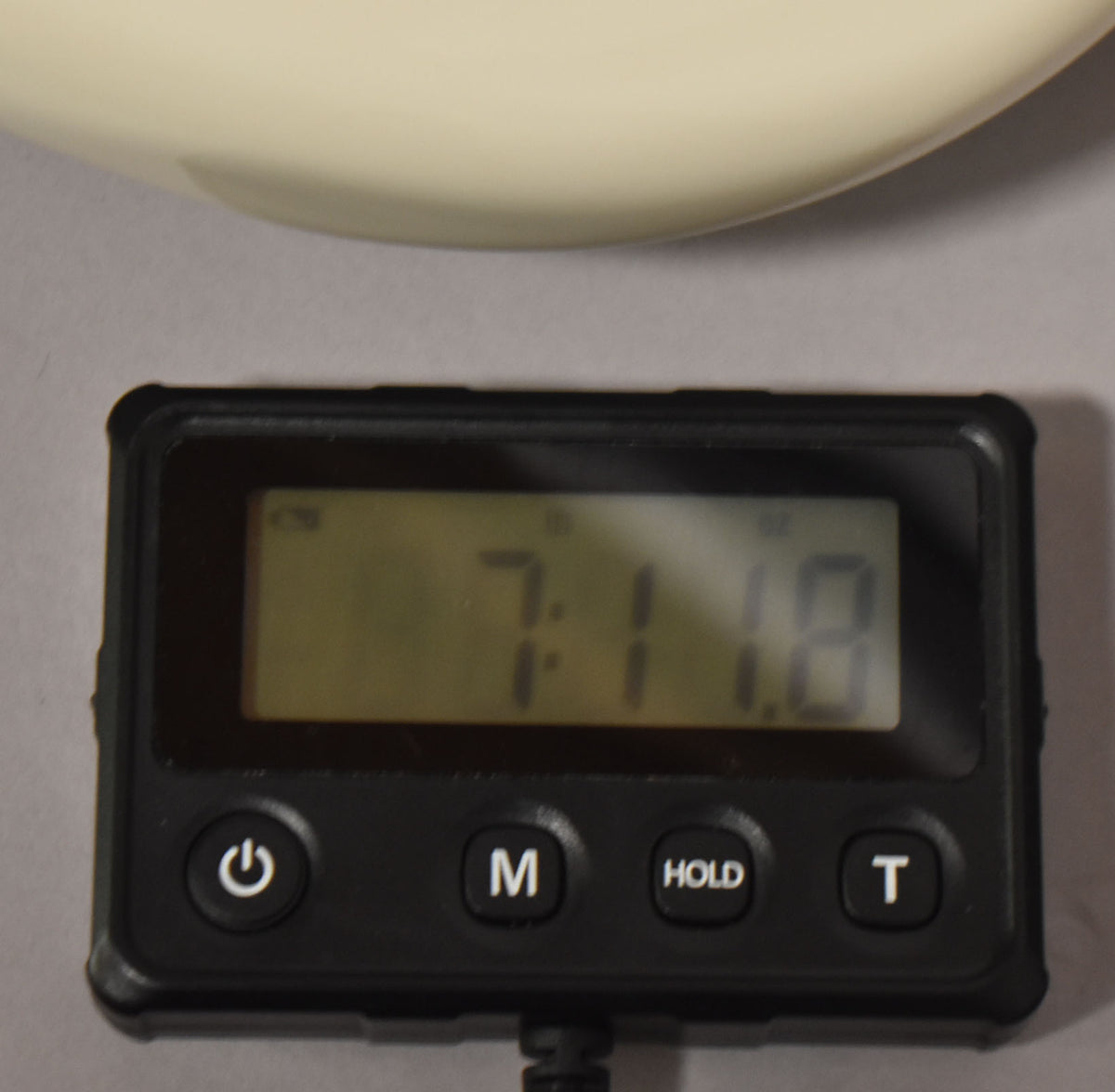 A digital scale displays "7:11.8" with the guitar's polar white body partially visible at the top.
