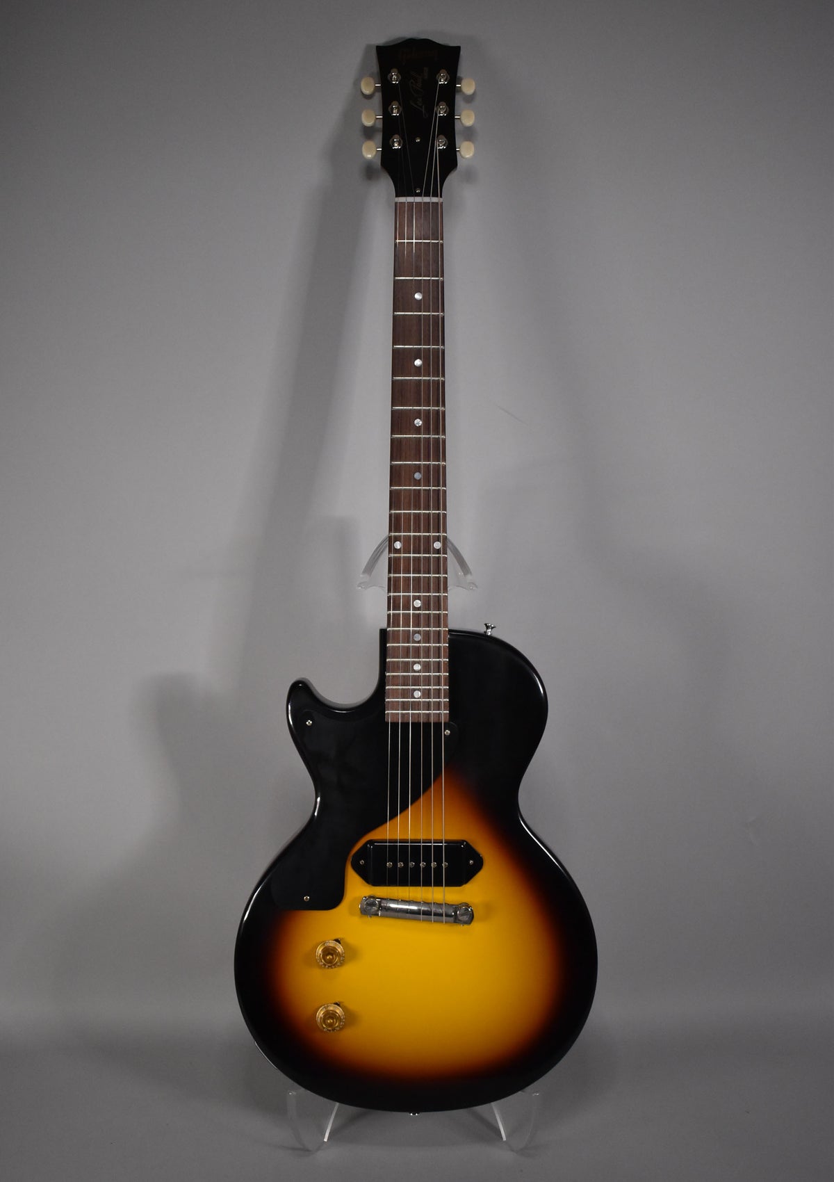 Full-length view of a left-handed Les Paul Junior in Vintage Sunburst, with a single P90 pickup, black pickguard, and two gold knobs.