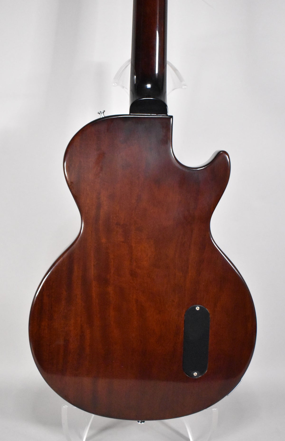 The back of a glossy, dark cherry sunburst electric guitar, showing the neck joint and a black control cavity cover.