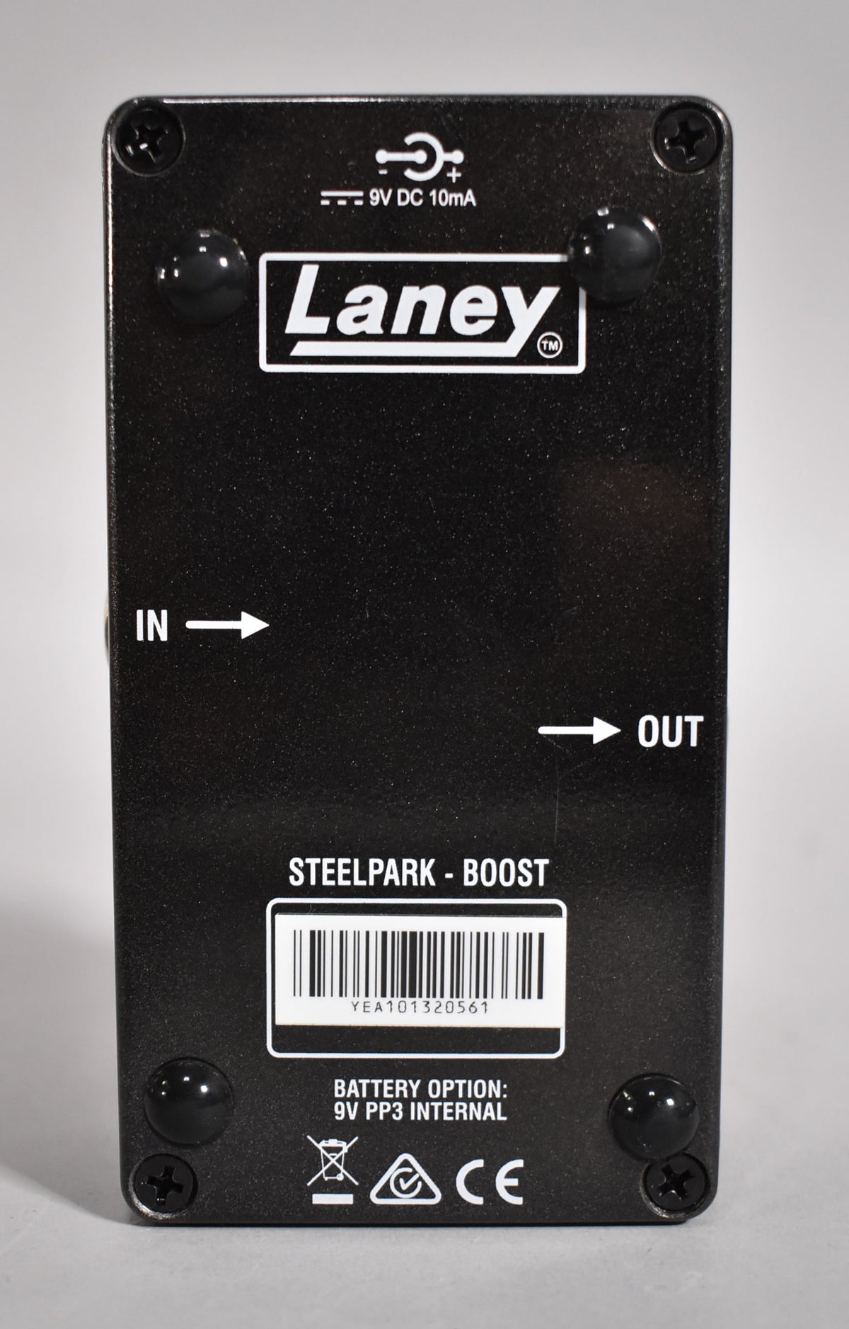 The black textured pedal is viewed from the back, showing four black screws, a barcode, and white text for power and battery info.