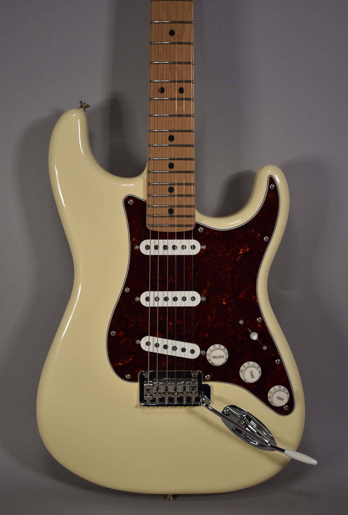Full front view of an Olympic White Stratocaster with a tortoiseshell pickguard, three white single-coil pickups, and a maple fretboard.