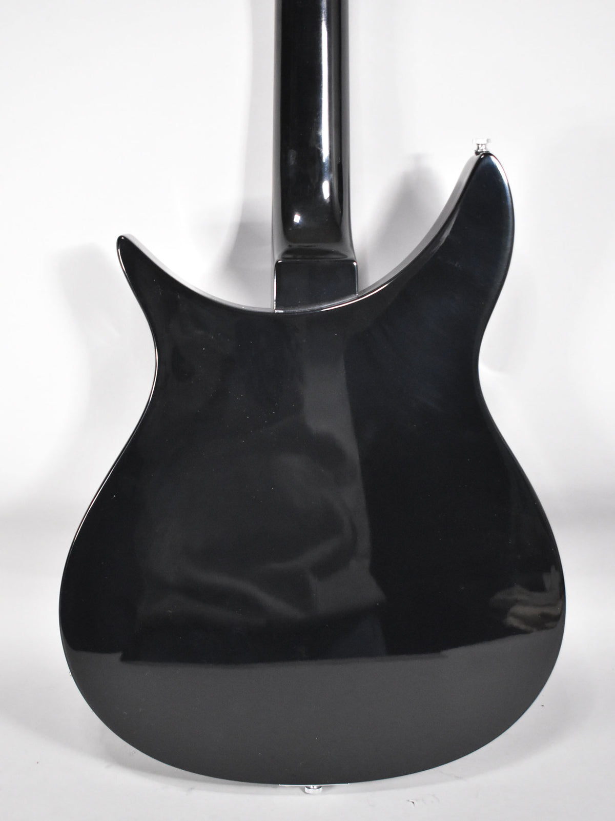 The back of a glossy black guitar, showing the neck joint and the upper and lower bouts.