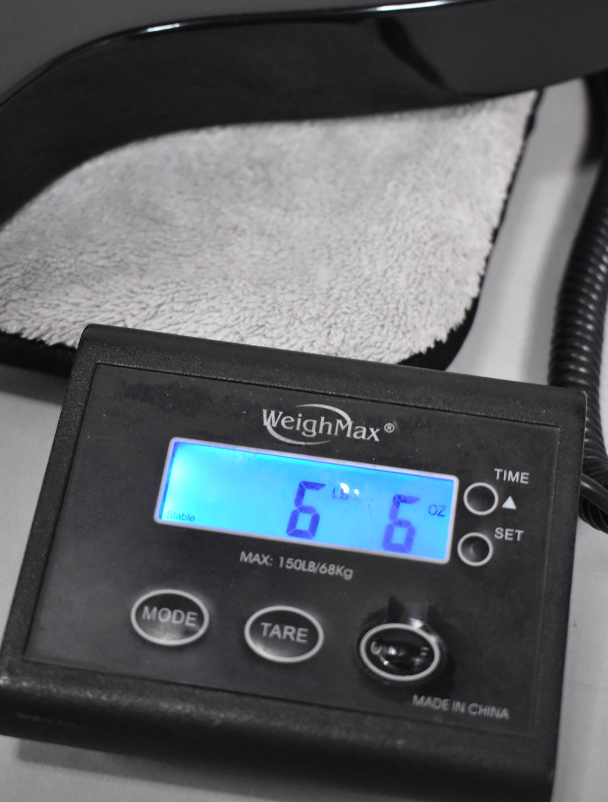 A black digital scale displays "6 6" in blue, showing the bass weighs 6 pounds, 6 ounces.