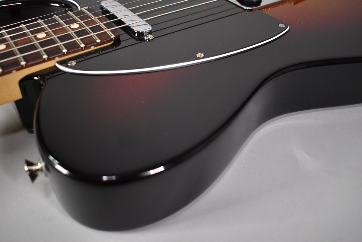Close-up of the Telecaster's lower body, showing the dark sparkle sunburst finish, black pickguard, and chrome bridge pickup.
