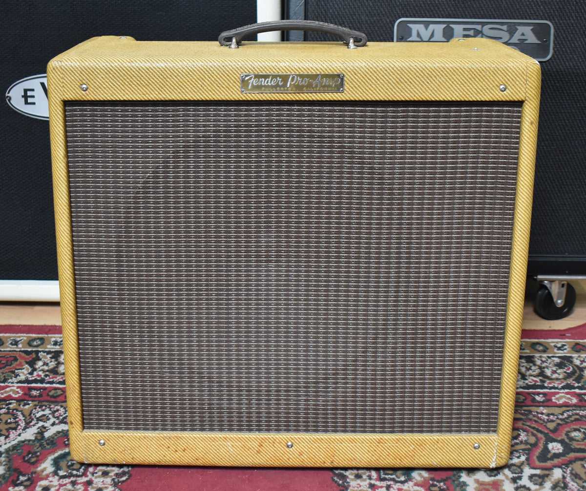 Full front view of a tweed amplifier with a brown grille, a dark brown handle, and a silver nameplate.