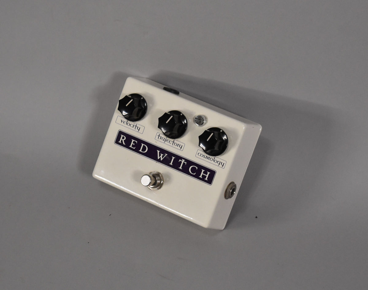Off-white guitar pedal with three black knobs labeled "velocity," "trajectory," and "cosmology," and a silver footswitch.
