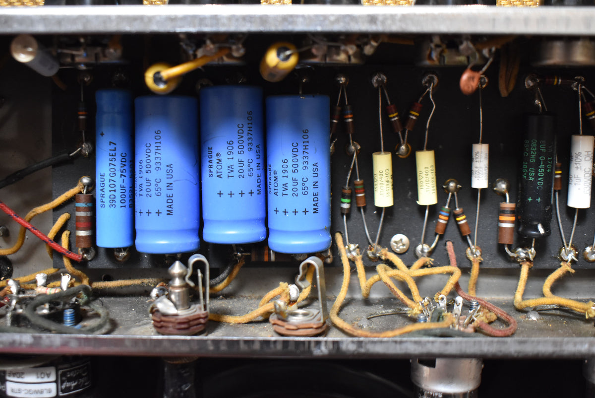 Close-up of the amplifier's internal components, showing several blue capacitors, resistors, and aged yellow wiring.