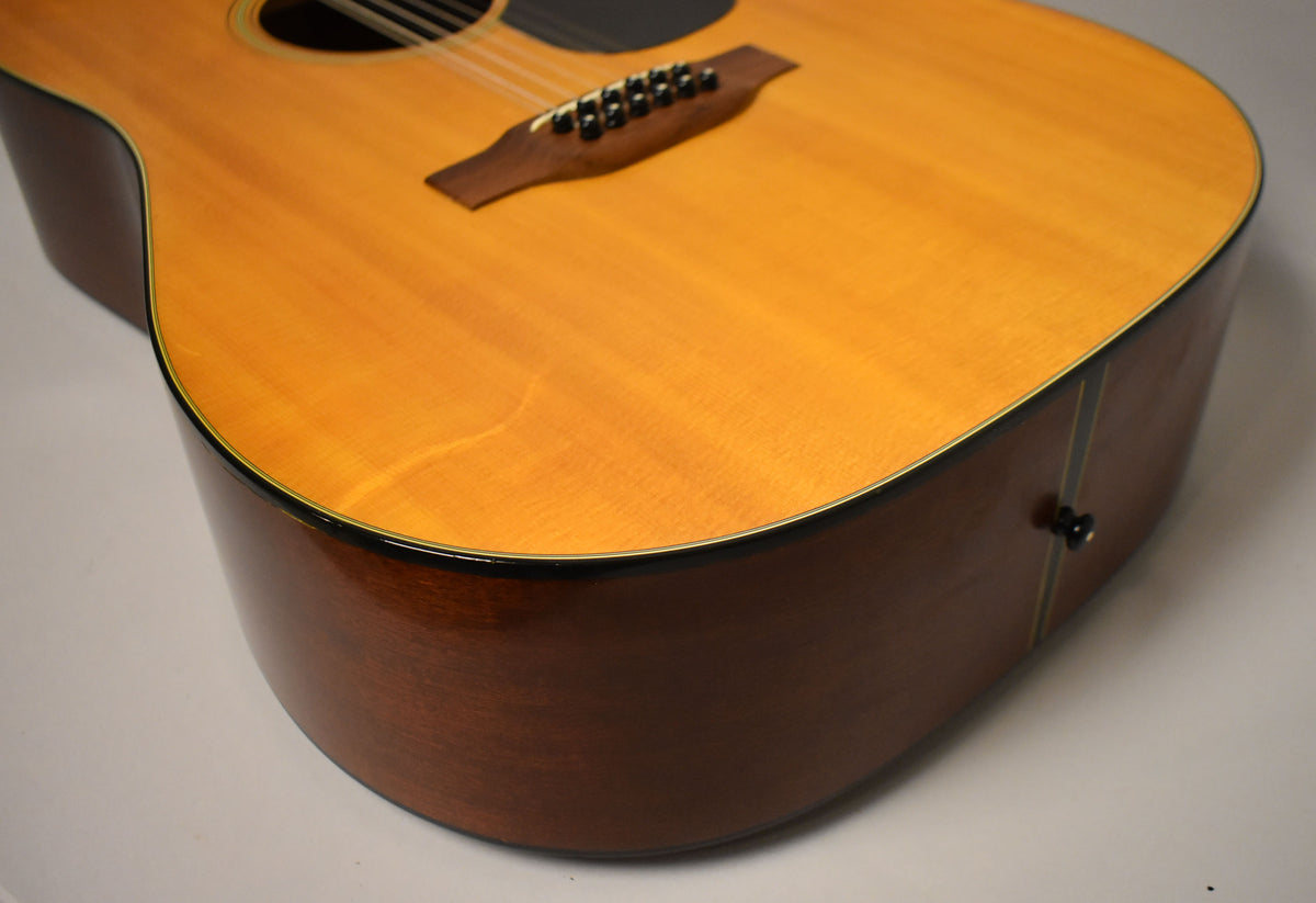 Close-up of the lower bout, showing the natural spruce top, dark wood sides, black binding, and a black end pin.