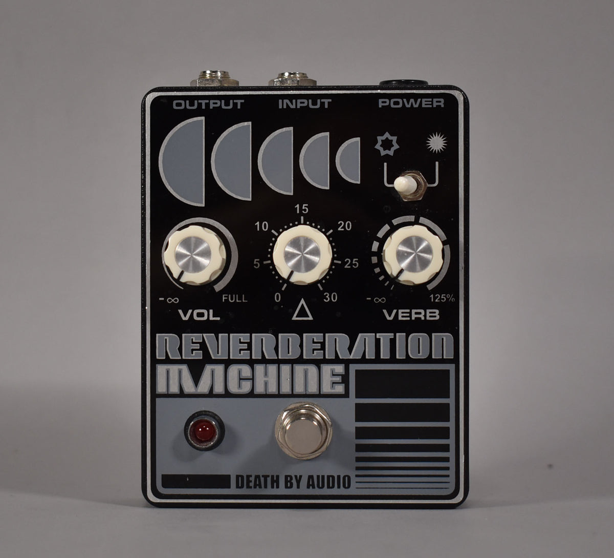 Black pedal with white trim, three cream-colored knobs, a red LED, and a silver footswitch, viewed from the front.