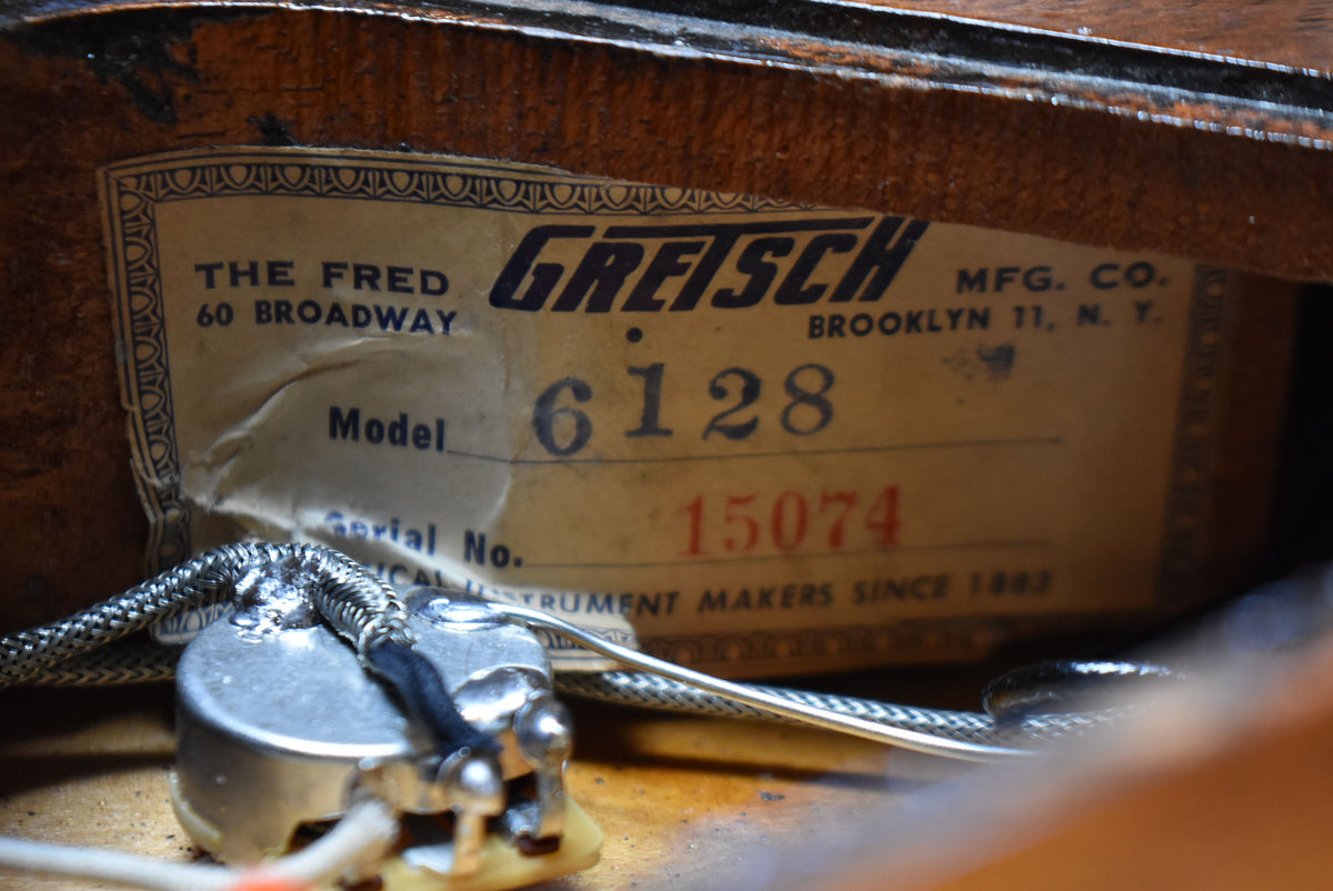 Close-up of the guitar's interior label, showing "Model 6128" and "Serial No. 15074" with wiring and a potentiometer in the foreground.