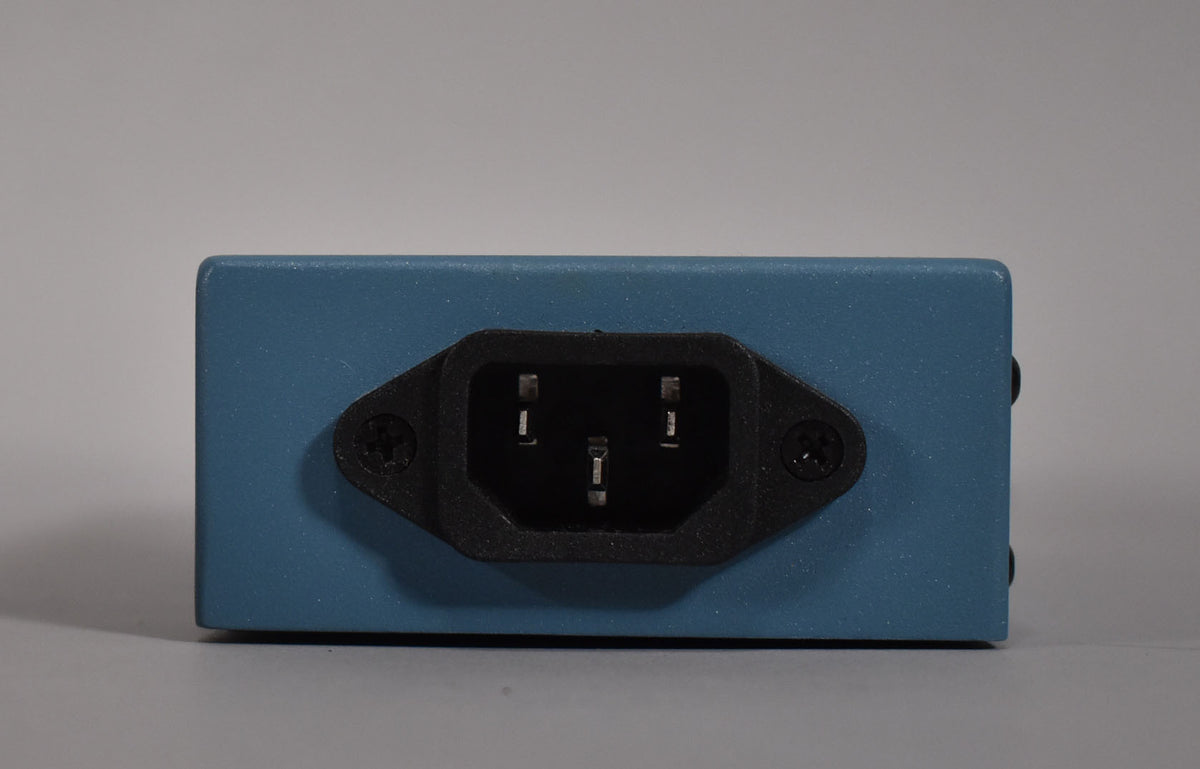 The rear of the blue power supply shows a black IEC C14 inlet, secured by two visible screws, with minor scuffs on the casing.