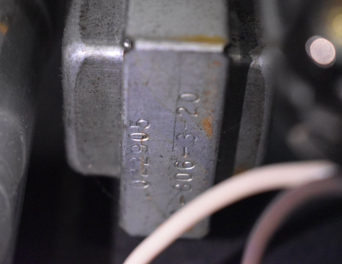 Close-up of a silver-grey metal component with stamped numbers "022905" and "-606-3-20", showing some rust and grime.