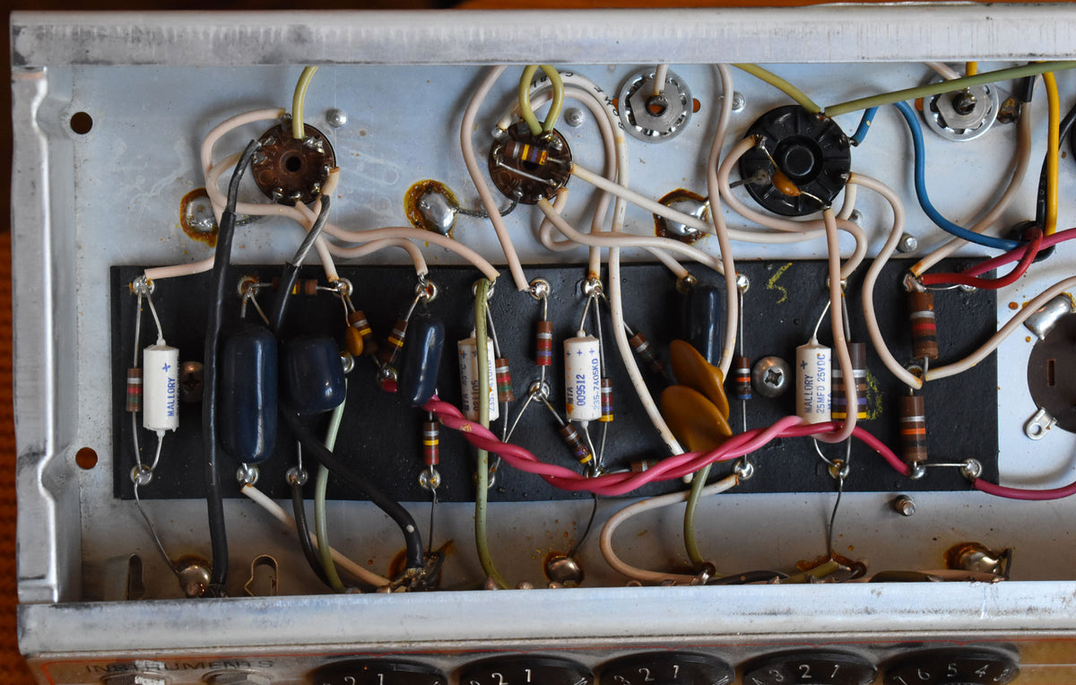 Overhead view of the amp's internal wiring, showing various colorful wires, resistors, and capacitors on a metal chassis.