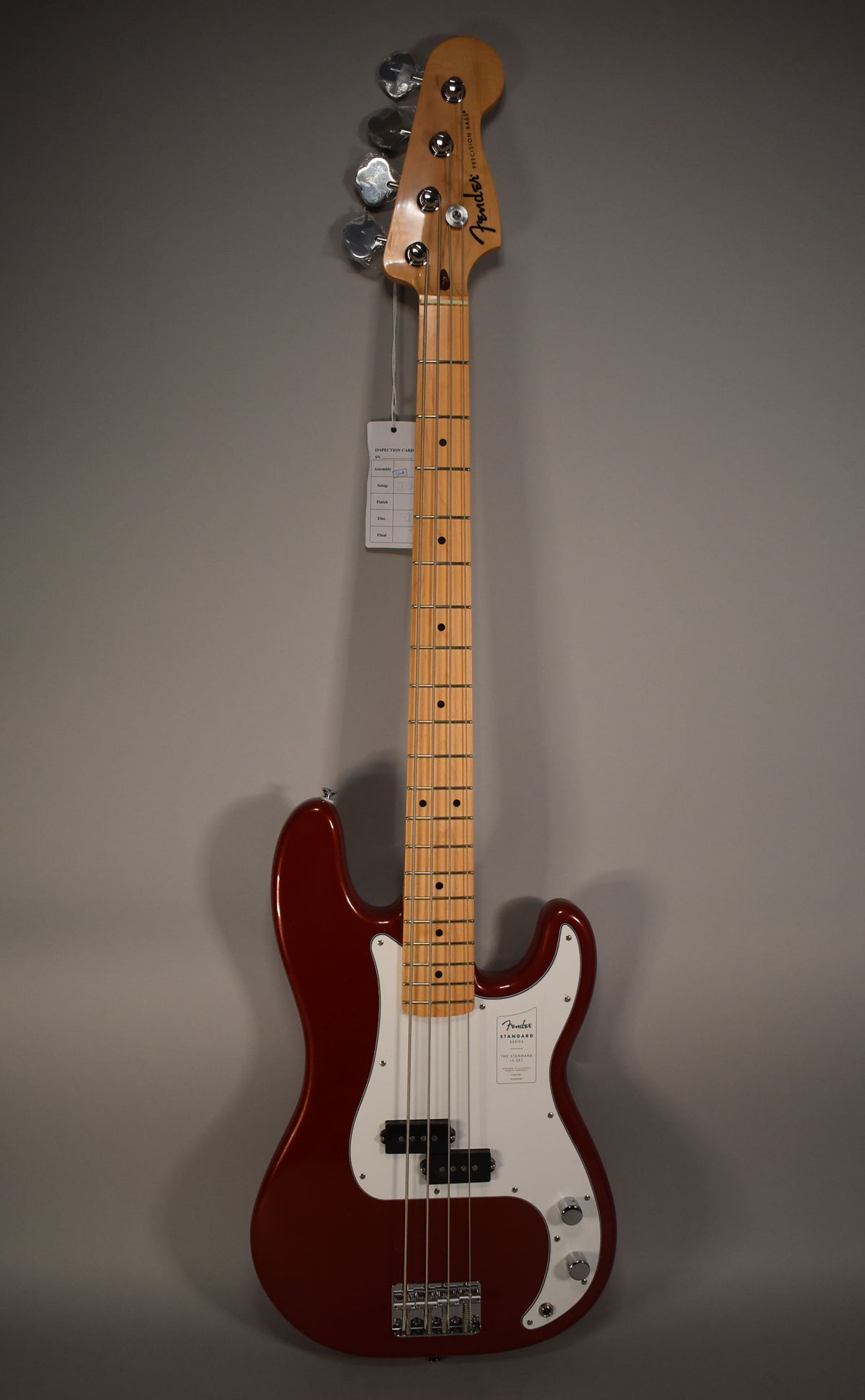 Full-length view of a glossy Candy Cola Precision Bass with a maple neck, white pickguard, and chrome hardware.