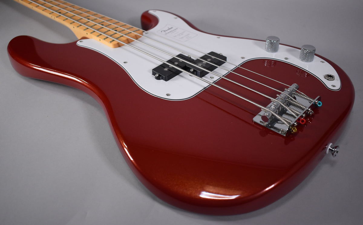 The metallic Candy Cola bass body, with a white pickguard, split pickup, and chrome bridge, is angled from the upper left.