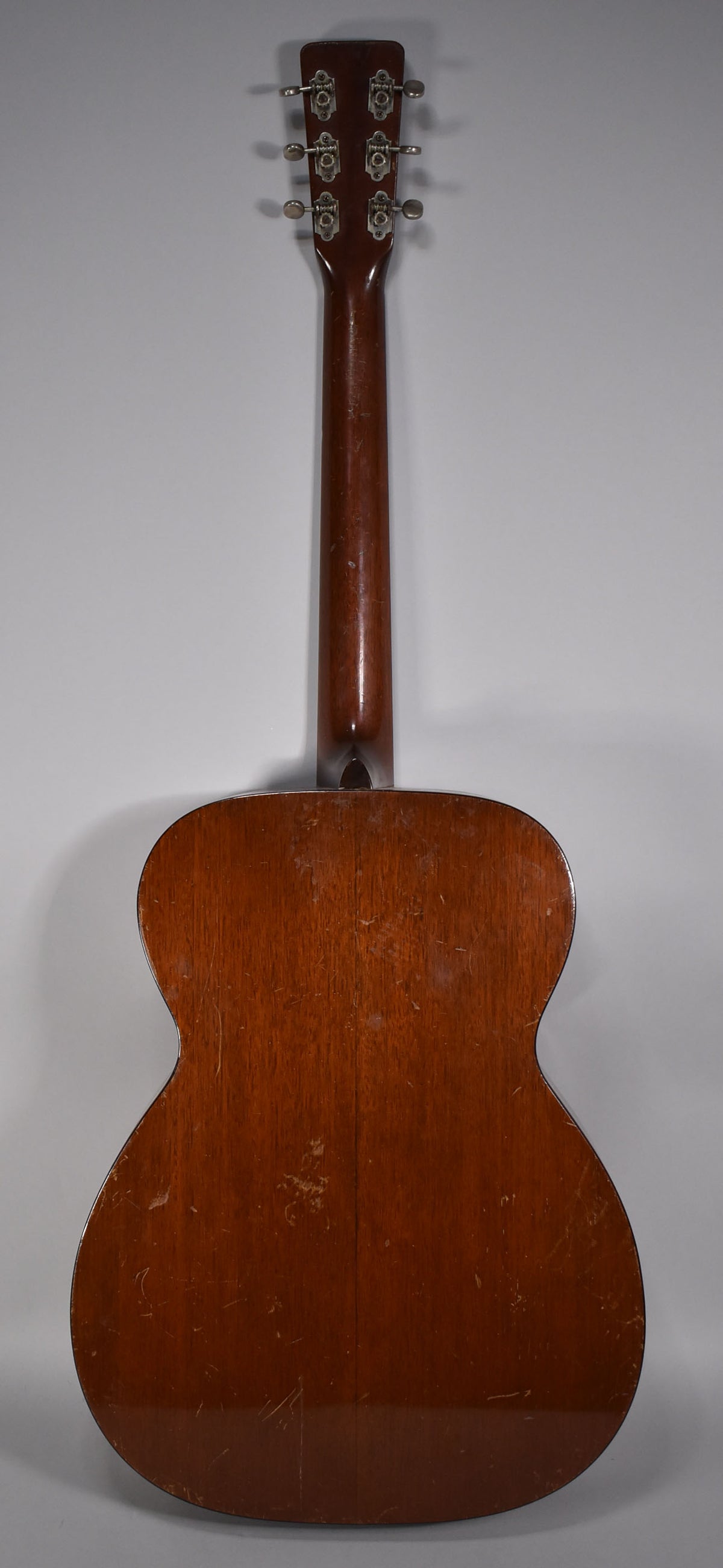 The guitar's back and neck are shown, with a natural finish and visible wear, scratches, and checking across the body.