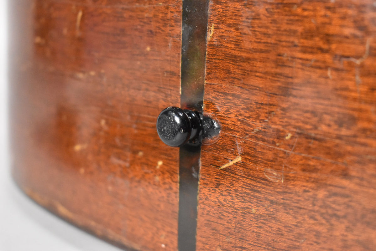 Close-up of the guitar's natural finish mahogany back, showing a black endpin and a dark center strip with visible wear and scratches.