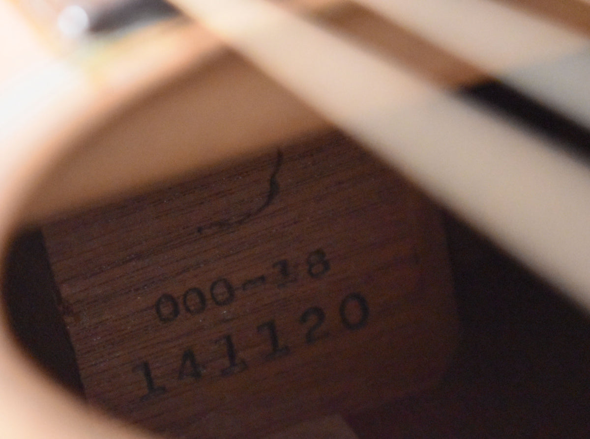 A close-up of the guitar's dark wood interior label, showing "000-18" and "141120" with a visible crack above.