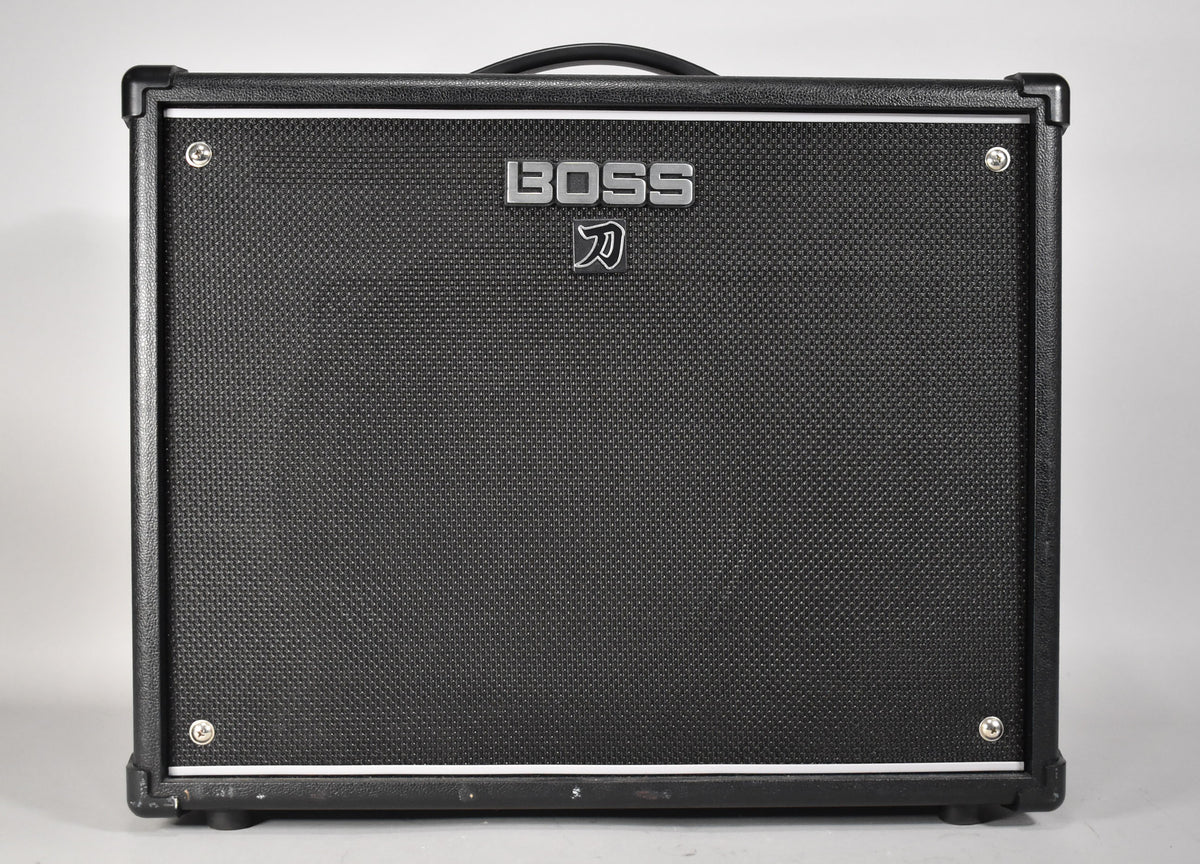 Front view of a black guitar combo amp with a textured grille, silver piping, and corner protectors.