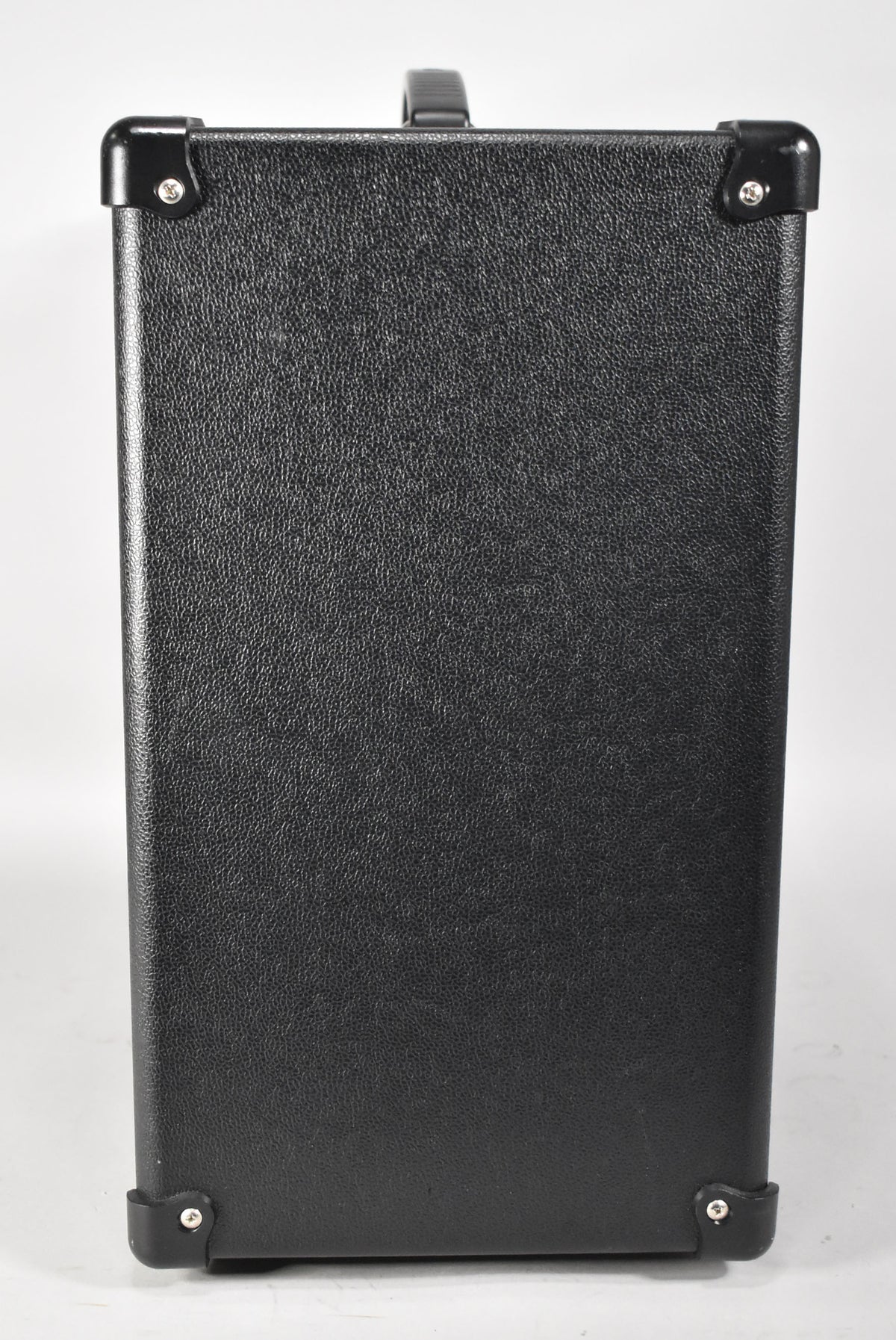 The amplifier is shown from the right side, revealing a black textured finish, four black corner protectors, and a top handle.