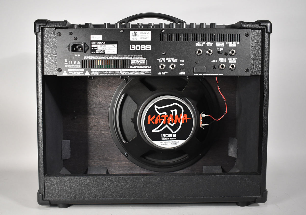 The amp's open back reveals a black speaker with a white and red Katana logo, and a rear panel with various input/output jacks.