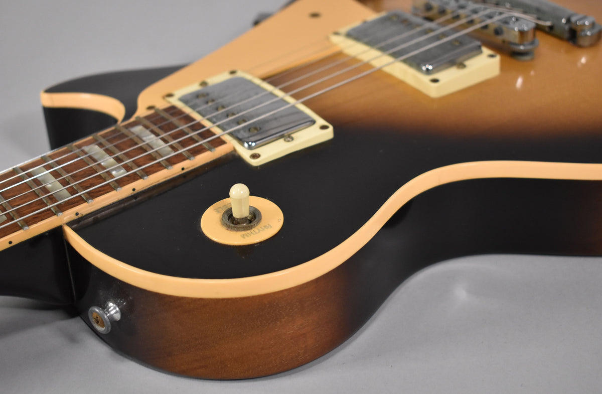 Close-up of the lower bout, showing the tobacco sunburst finish, cream binding, pickup selector switch, and output jack.