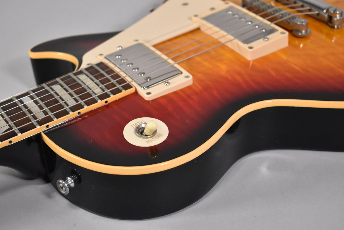 Angled view of the guitar's lower bout, showing the Tri-Burst finish, cream binding, pickup selector switch, and strap button.