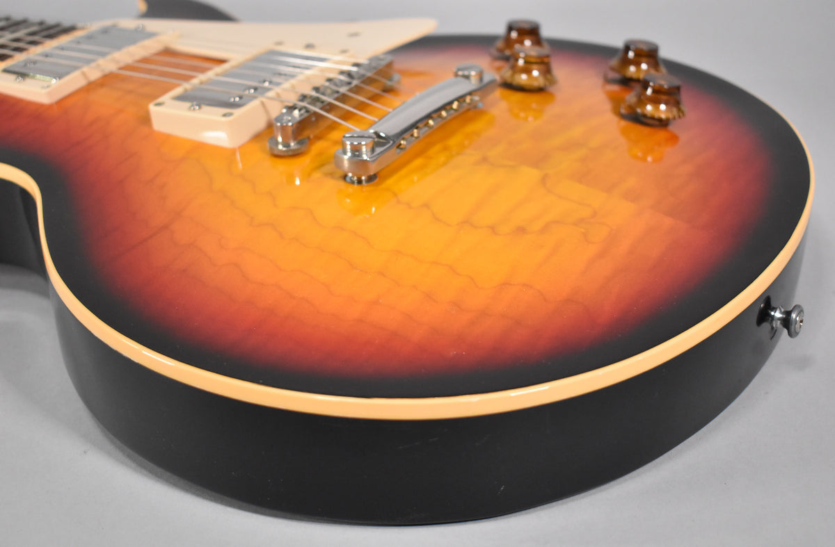 Close-up of the guitar's lower bout, showing the Tri-Burst finish with flame maple top, cream binding, and amber control knobs.