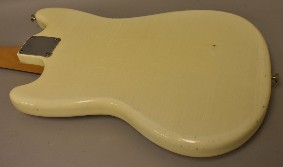The back of the Olympic White guitar body, showing a relic nitro finish with visible checking, a neck plate, and strap buttons.