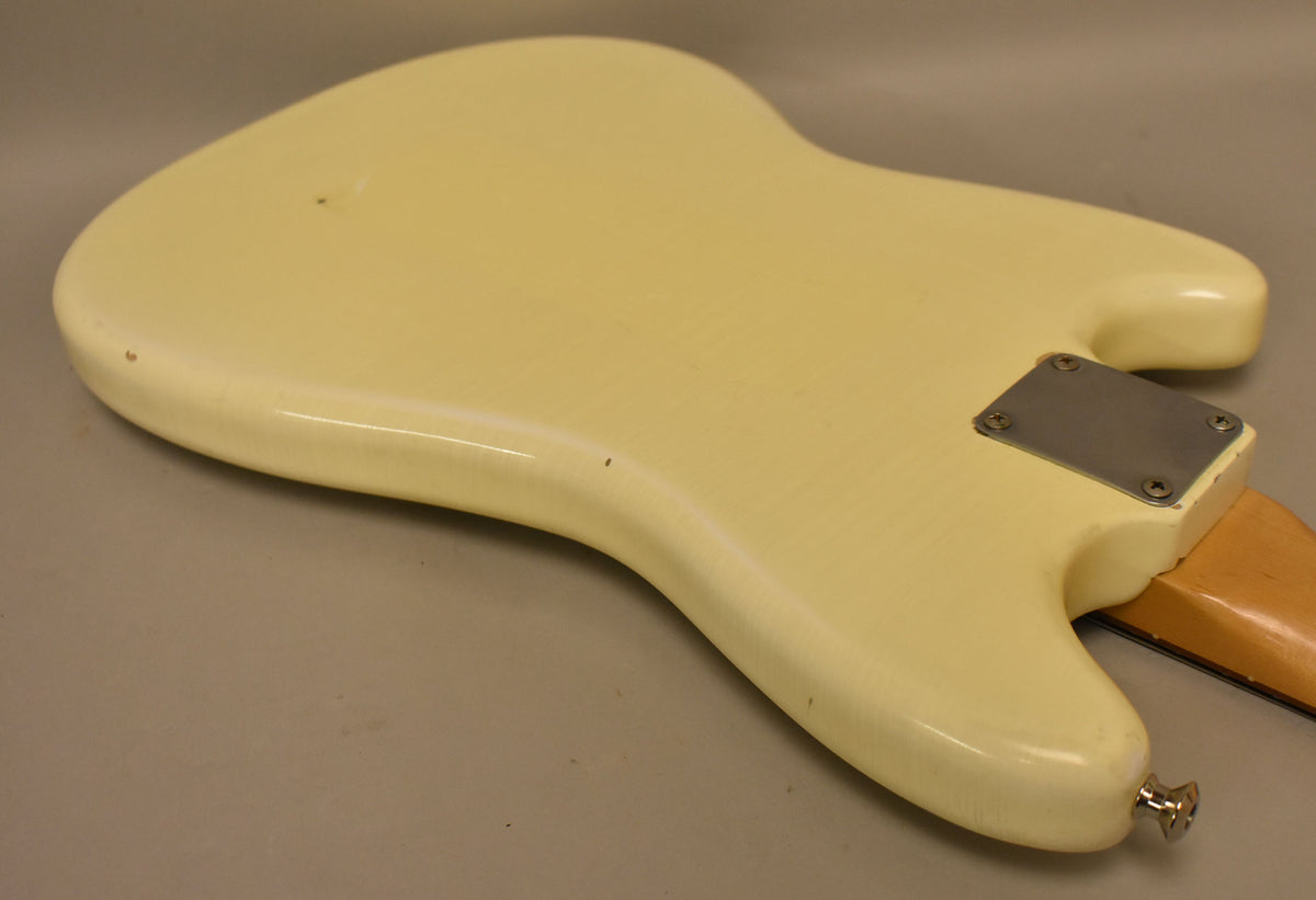 The Olympic White guitar body, viewed from the back, shows a relic nitro finish with visible checking, dings, and a chrome strap button.