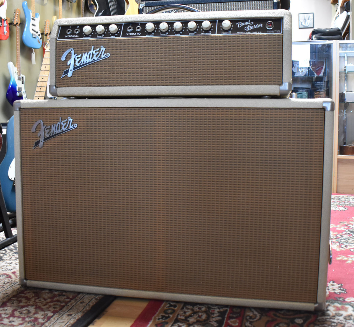 Full front view of a blond amp head with white knobs and a matching 2x12 cabinet, both with brown grille cloth and silver corner protectors.