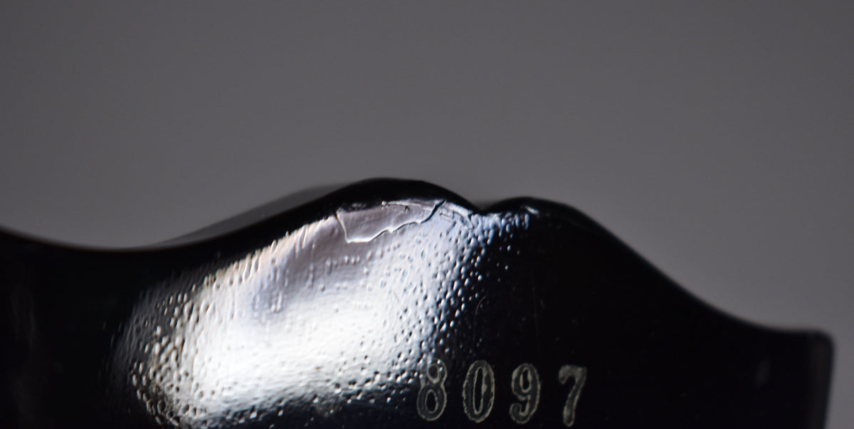 Close-up of the guitar's black headstock, showing a chipped finish near the top edge and the serial number "8097" embossed below.