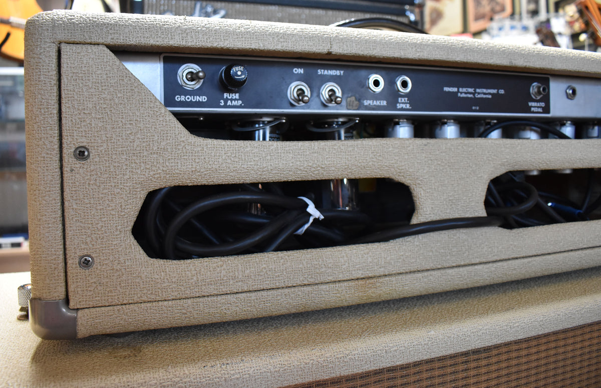 Close-up of the amp's rear panel, showing the blonde tolex, black control plate with switches and jacks, and visible tubes.
