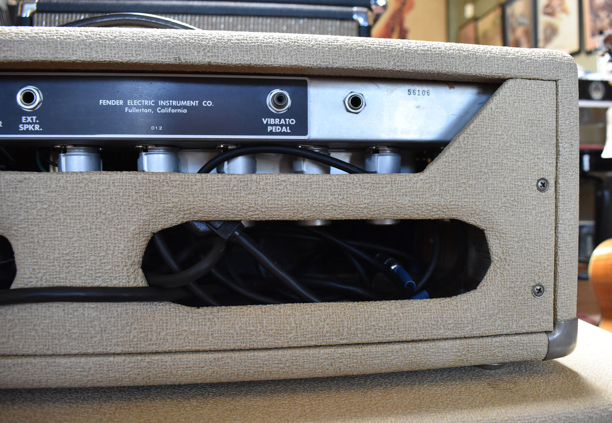 Rear view of the blond tolex amp head, showing the black control panel with input jacks and a cutout revealing internal wiring.