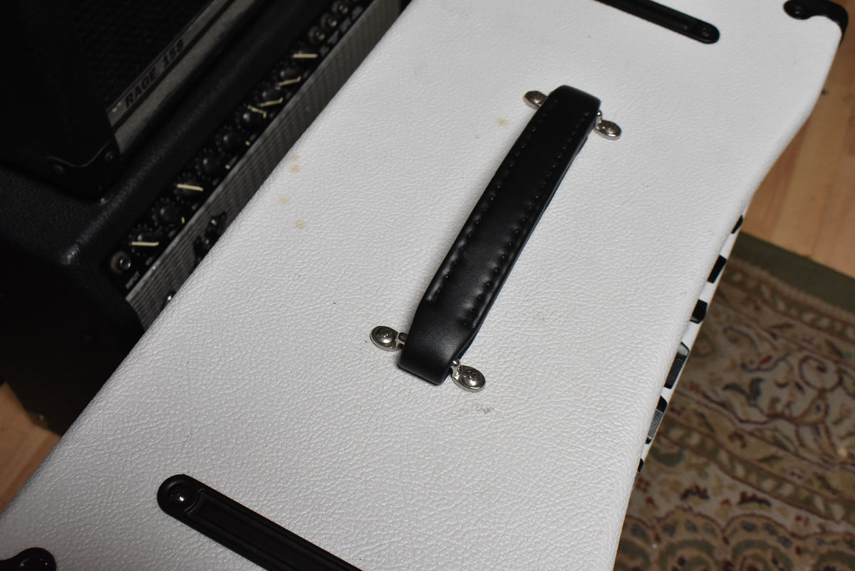 Top-down view of the white tolex amplifier, showing the black leather handle and some light brown stains on the textured surface.