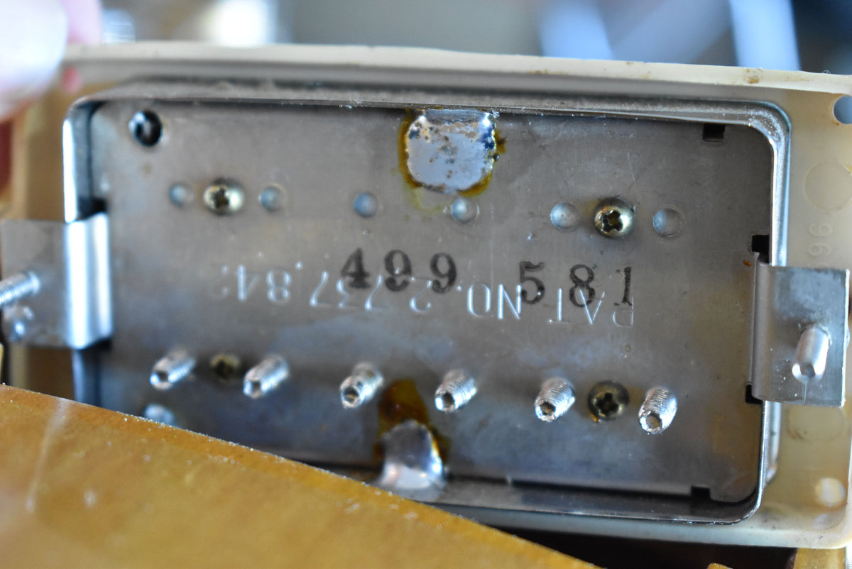 Close-up of a tarnished chrome pickup baseplate with visible solder joints, screws, and "PAT. NO. 2,737,842" and "499581" stamped.