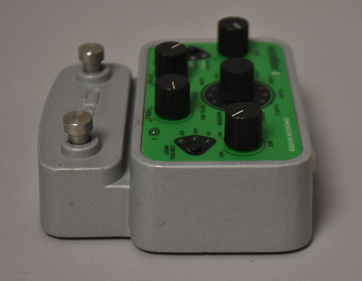 A silver-grey pedal with a bright green top panel, featuring two silver footswitches and six black control knobs.