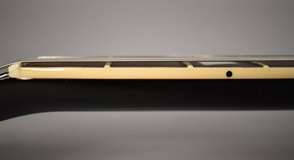 Close-up of the guitar's neck, showing the dark fretboard, cream binding, and a black side dot marker.