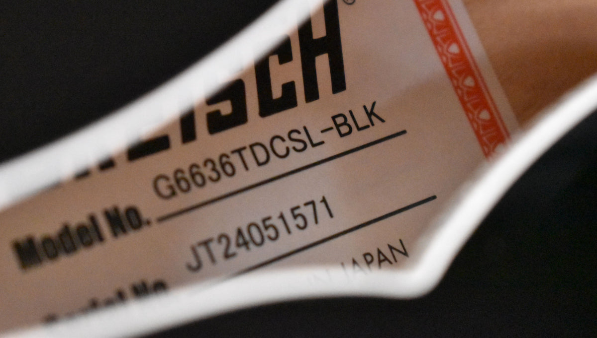 A close-up of the guitar's label, showing "Model No. G6636TDCSL-BLK" and "JT24051571" on a light tan paper.