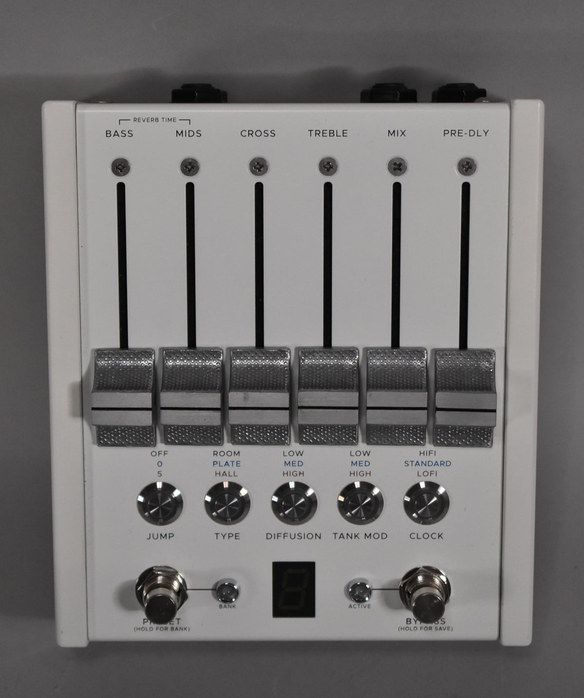 A white effect pedal with six silver fader controls and five silver rotary knobs, two footswitches, and a small digital display.