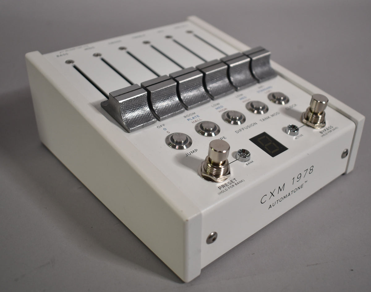 White effect pedal, angled from the right, showing six silver fader caps, nine silver push buttons, two footswitches, and a digital display.