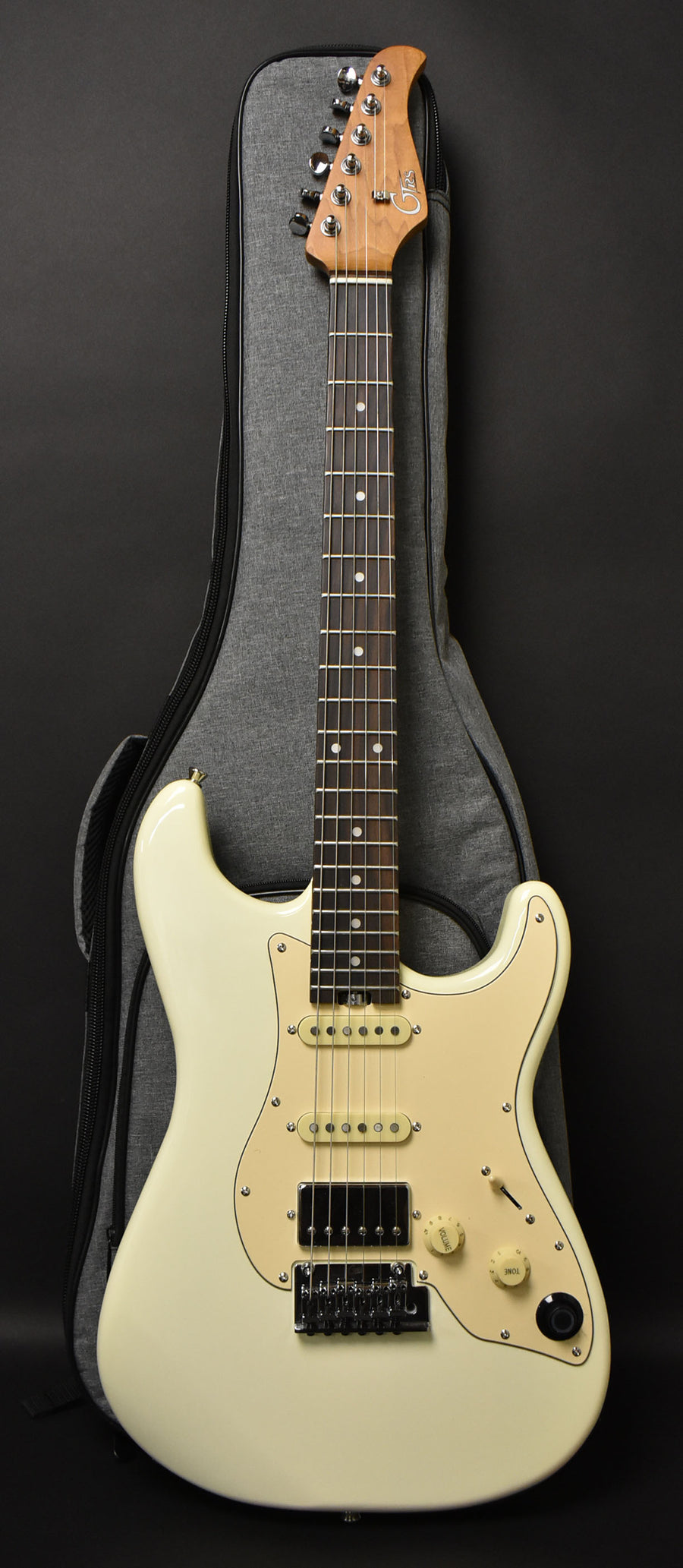 Full-length view of a vintage white electric guitar with a cream pickguard, two single-coil pickups, a humbucker, and a tremolo bridge.